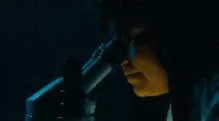 Dark film still showing a woman illuminated at night